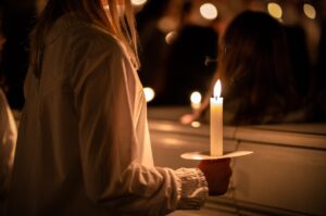 Menschen mit Kerzen in den Händen. Weihnachten und Lucia Feiertage in Schweden
