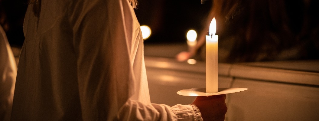 Menschen mit Kerzen in den Händen. Weihnachten und Lucia Feiertage in Schweden